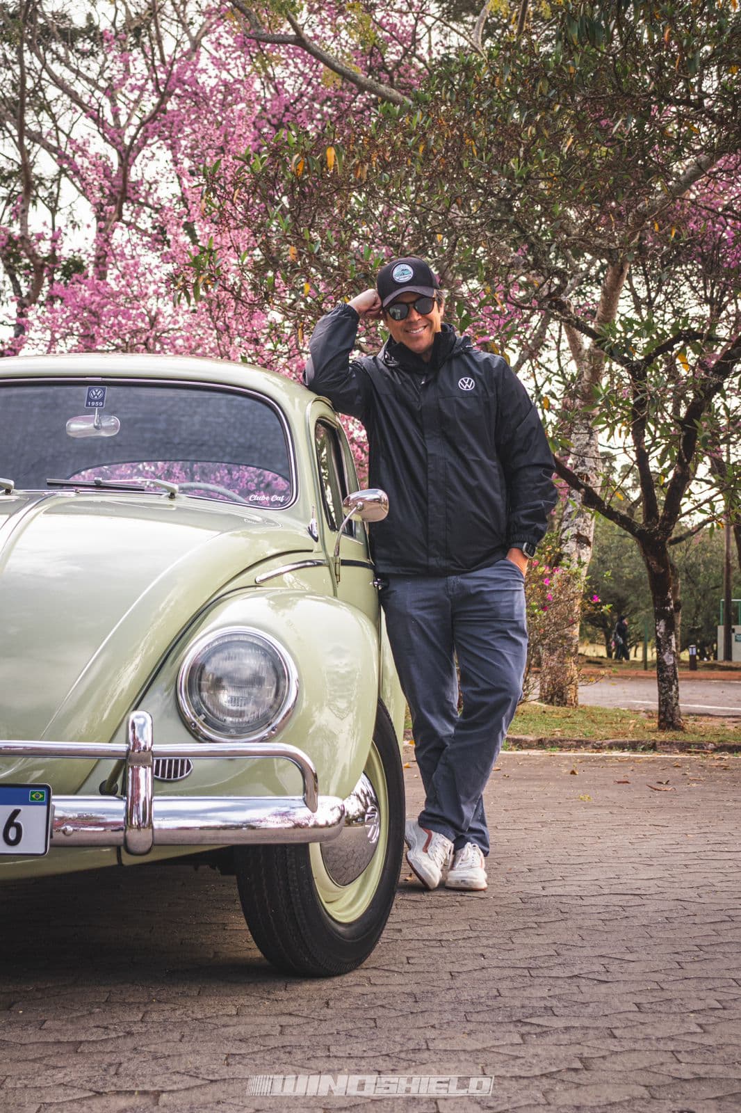 Claudio Costa posando ao lado de um fusca alemão de 1959
